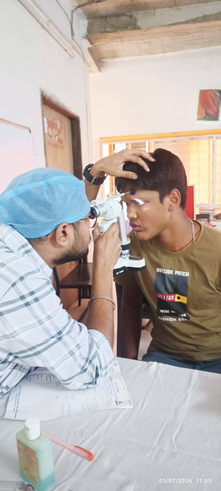 Doctor conducting free eye examination for a student at Voice of World Aaspriha Bhavan during the July 1 eye checkup camp